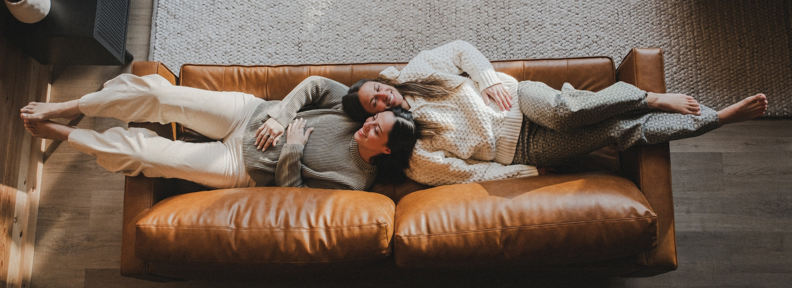 two girls laying on couch in Jetty Sweaters