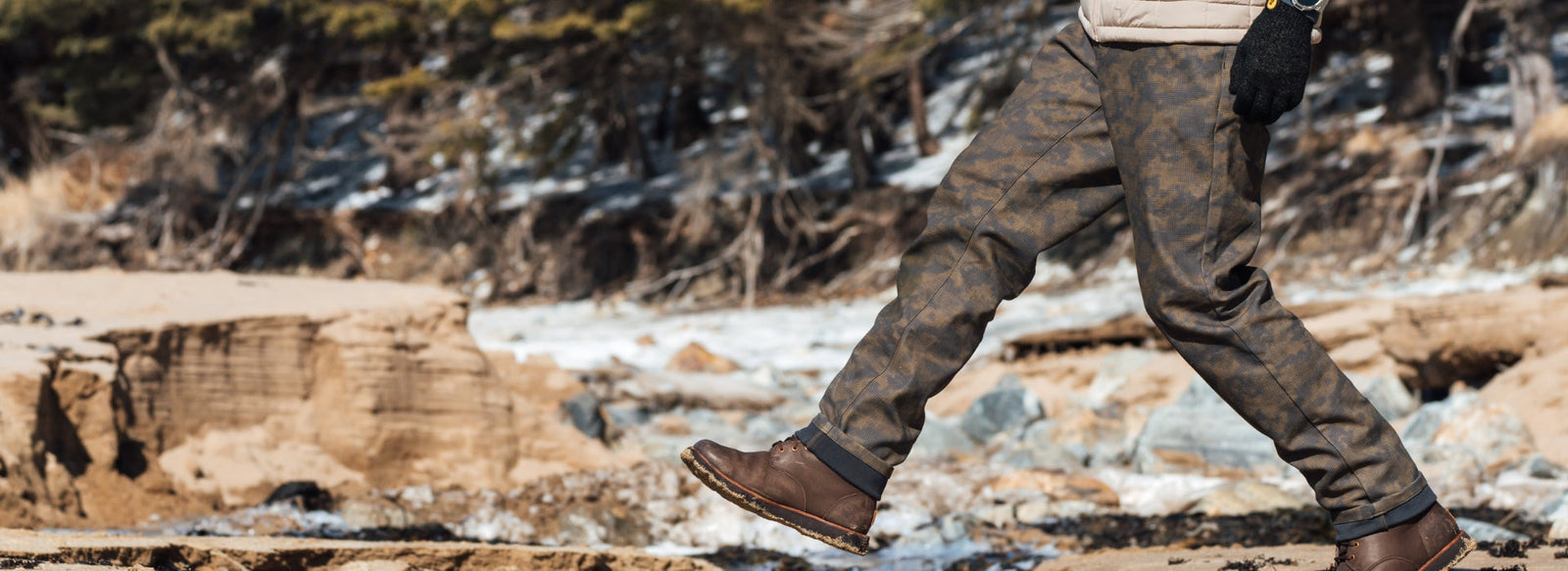 Someone crossing rocks and water in bedrock pant