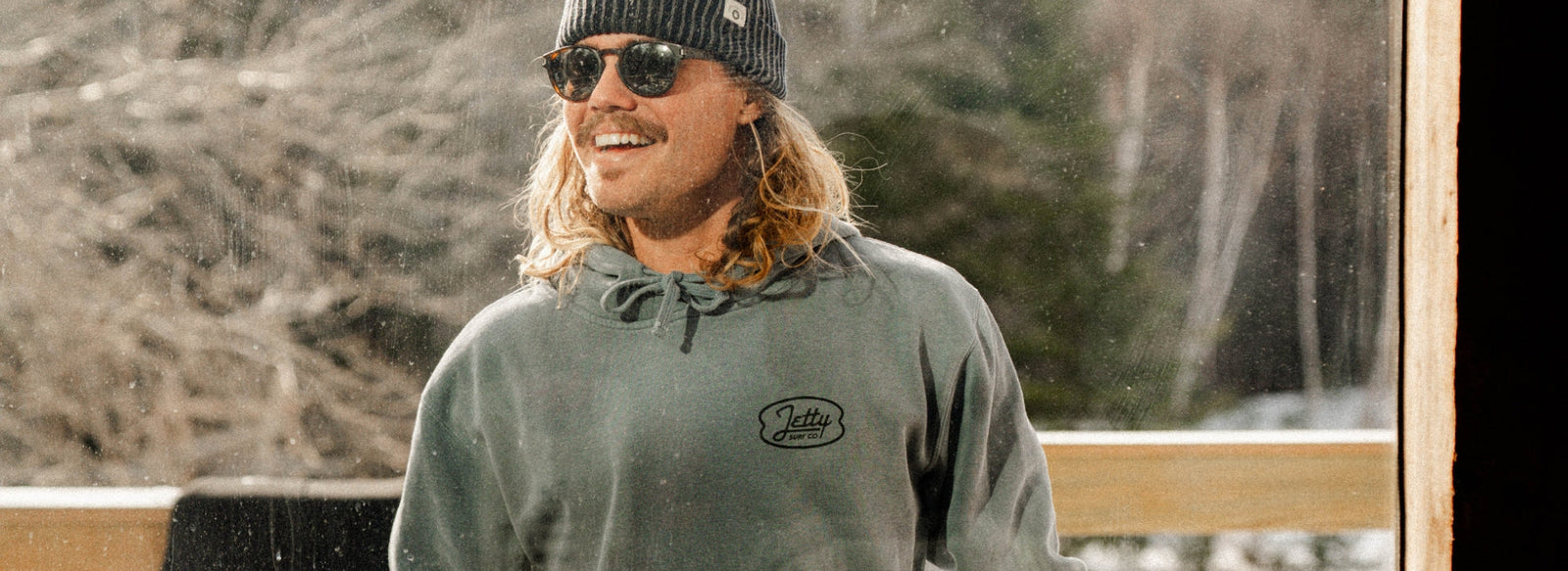 Man wearing Jetty Hoodie outside window
