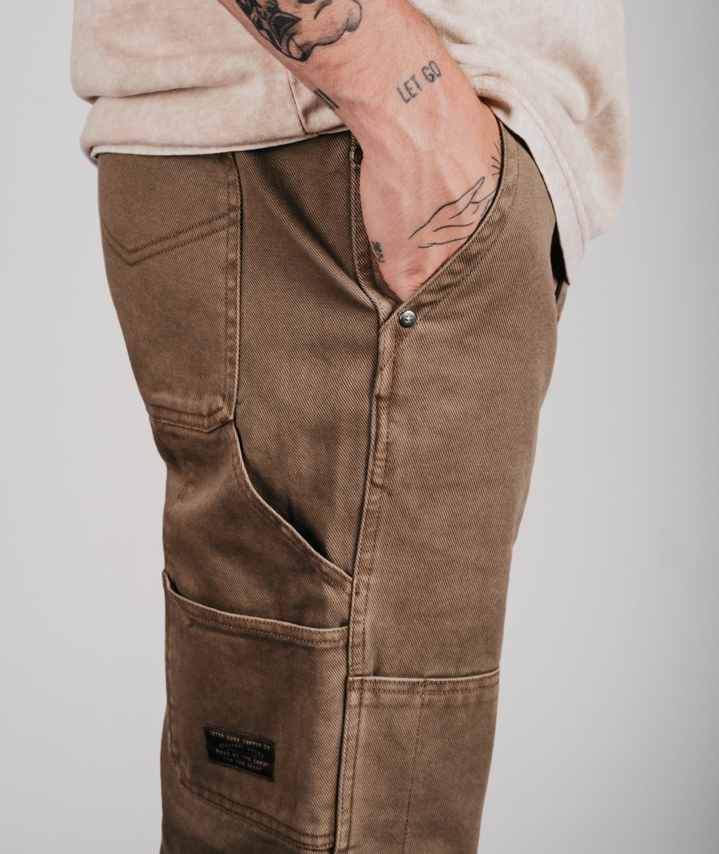 Brown pants worn by a person with a plain background