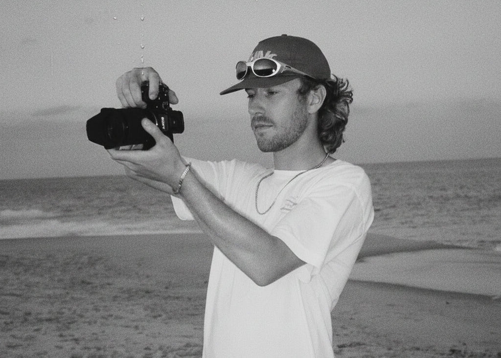 Man taking a selfie on a beach with ocean and sky in the background